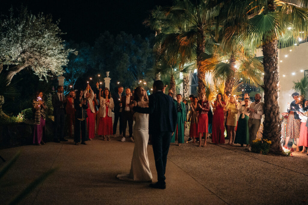 Mariage élégant sous les palmiers, couple célébrant l'amour avec leurs invités. Photographie lifestyle.